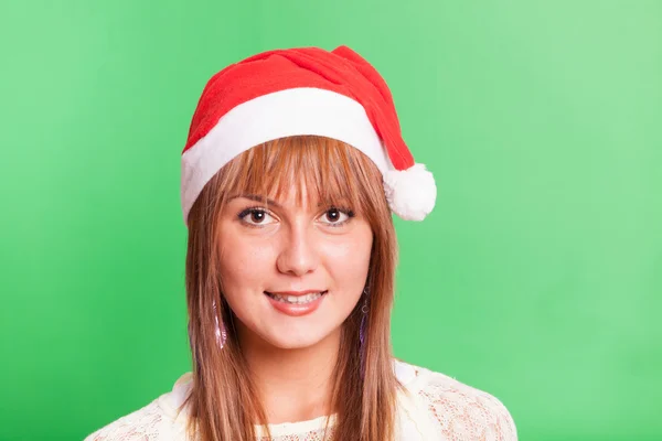 Fröhliche Frau mit Weihnachtsmütze auf grünem Hintergrund — Stockfoto