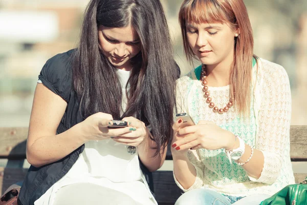 Twee jonge vrouwen met mobiele telefoon — Stockfoto