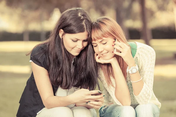 Twee jonge vrouwen met mobiele telefoon — Stockfoto