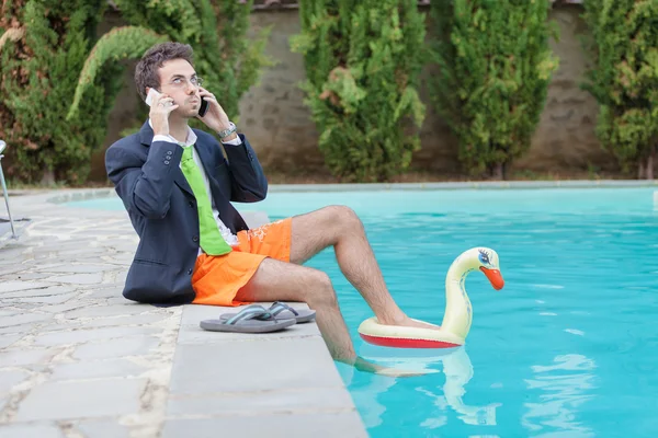 Śmieszne młody biznesmen z swimmingtrunks przy basenie — Zdjęcie stockowe