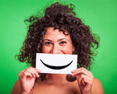 junge Frau mit Smiley-Emoticon auf grünem Hintergrund