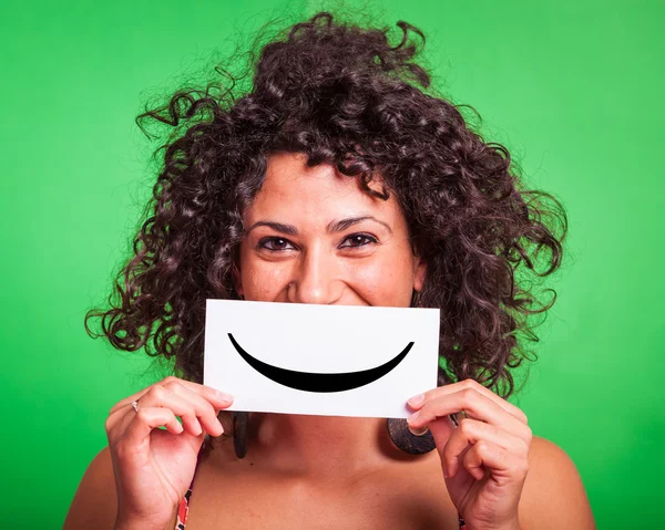 Mujer joven con emoticono sonriente sobre fondo verde — Foto de Stock