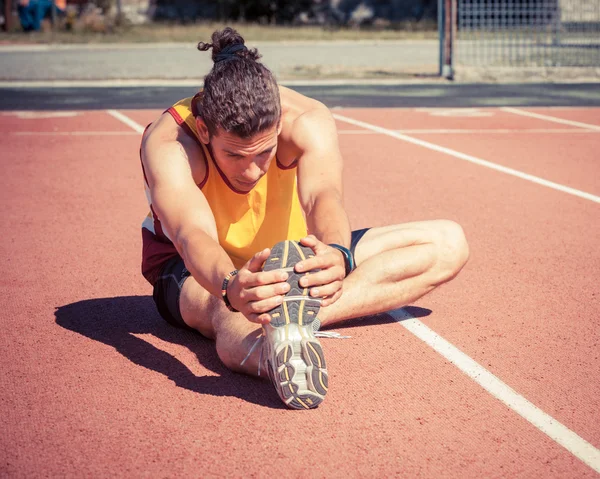 Track and Field Athlete Stretching — Stock Photo, Image