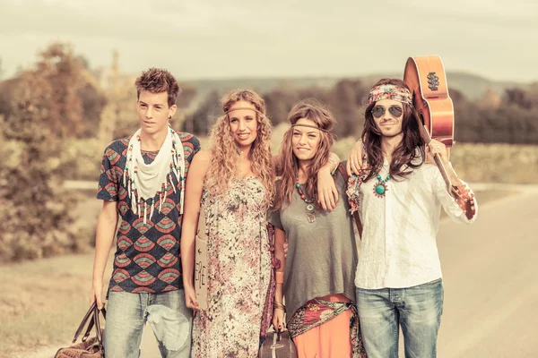 Grupo Hippie Caminhando em uma estrada do campo — Fotografia de Stock