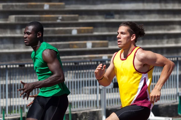 To atleter på banen, der løber - Stock-foto