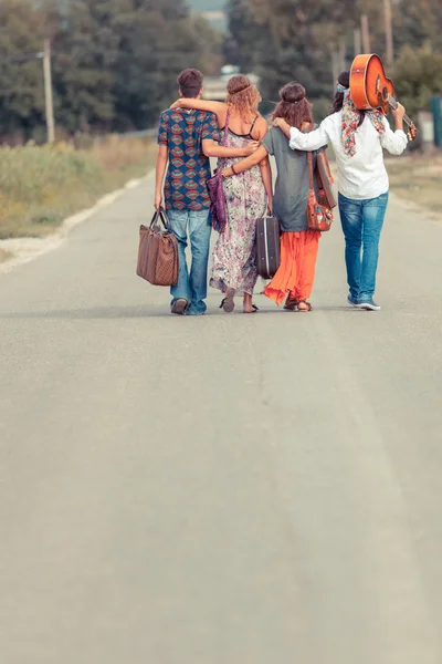 在农村道路上行走的嬉皮士组 — 图库照片