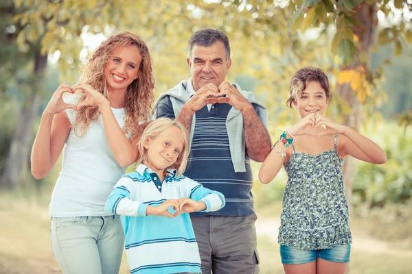 Família feliz com as mãos em forma de coração — Fotografia de Stock