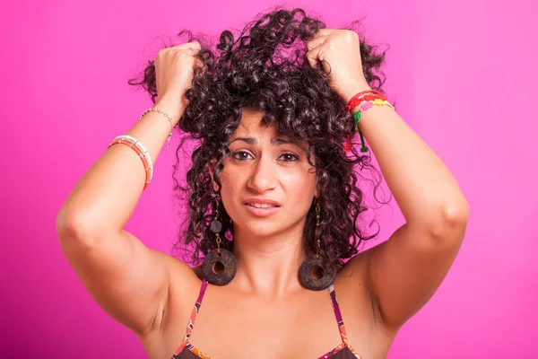 Mujer joven sosteniendo sus cabellos rizados — Foto de Stock