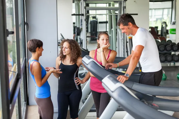 Hombre atractivo en el gimnasio con tres mujeres — Foto de Stock