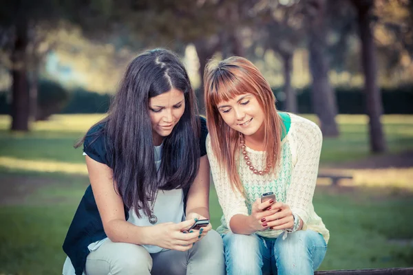 Две молодые женщины с мобильным телефоном — стоковое фото