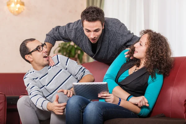 Tre vänner med TabletPC på en soffa — Stockfoto