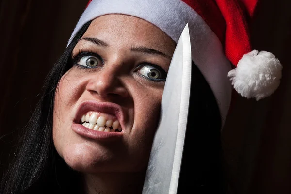Slechte vrouw met kerstmuts en mes — Stockfoto