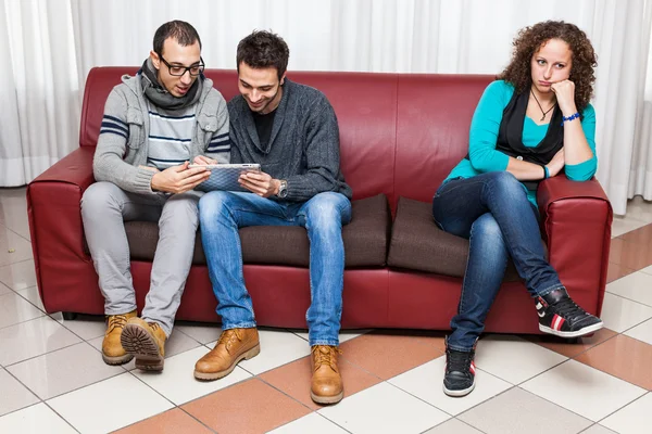 Uttråkad kvinna och män spelar med TabletPC — Stockfoto