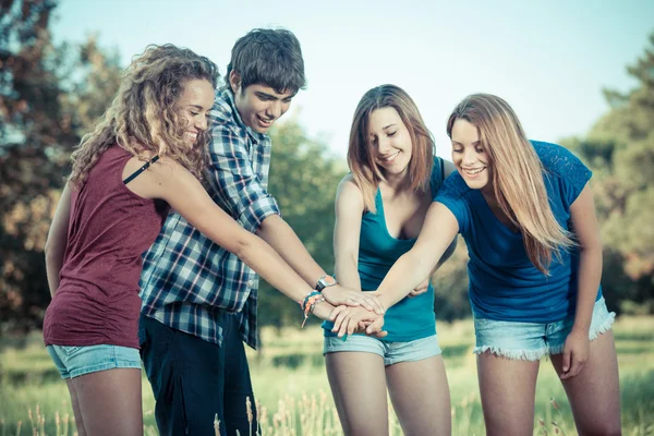 Skupina teenagerů s rukama na zásobníku — Stock fotografie