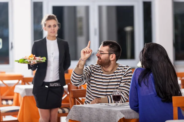 Pareja joven en el restaurante con camarera — Foto de Stock