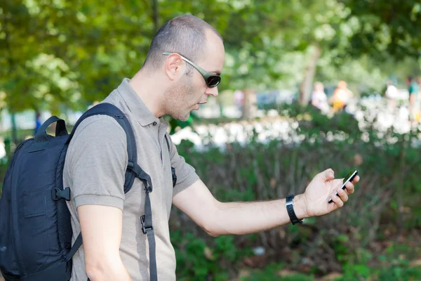Человек с мобильным телефоном в парке — стоковое фото