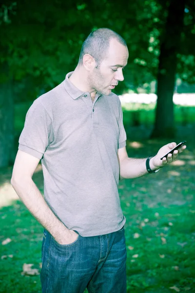 Людина з мобільного телефону в парку — стокове фото