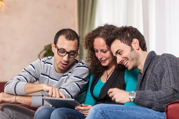 Tres amigos con Tablet PC en un sofá —  Fotos de Stock