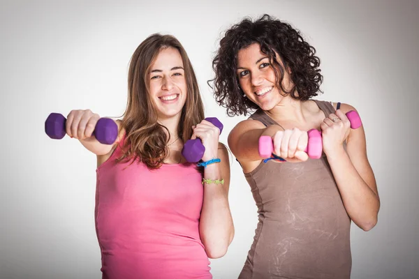 Dos mujeres con pesas ligeras en el gimnasio — Foto de Stock