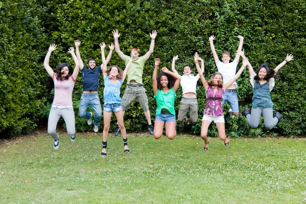 Heureux étudiants du collège d'adolescence sautant au parc — Photo