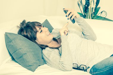 güzel bir genç kadın kanepe smartphone ile