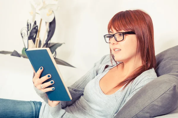 Mooie jonge vrouw met een boek op de Bank — Stockfoto