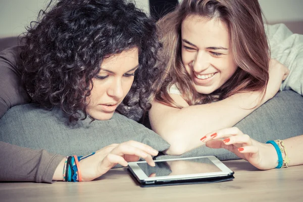 Dos hermosas mujeres con Tablet PC en el dormitorio —  Fotos de Stock