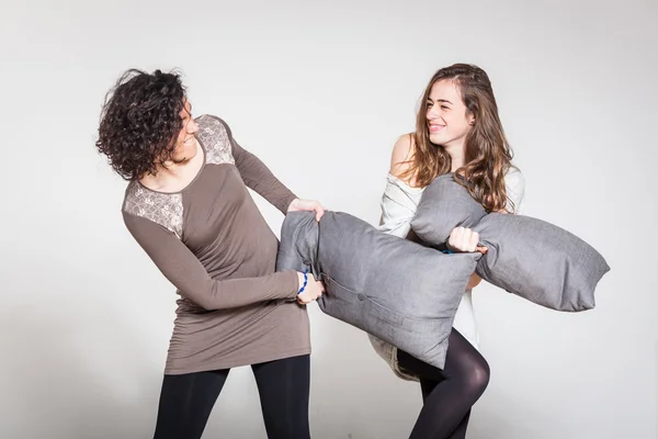 Борьба подушками между двумя красивыми женщинами — стоковое фото
