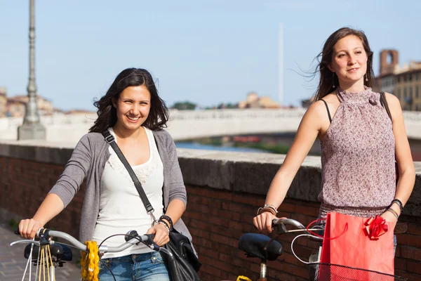 Deux belles femmes marchant dans la ville avec des vélos et des sacs — Photo