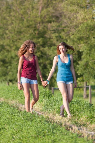 Twee mooie tiener meisjes lopen's park — Stockfoto