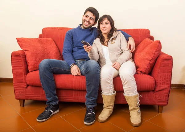 Jovem casal assistindo TV no sofá — Fotografia de Stock