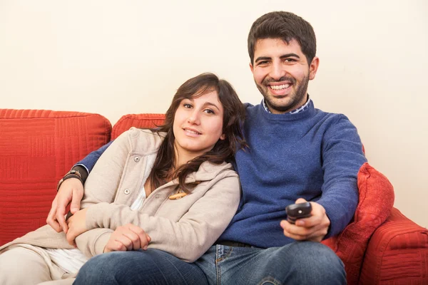 Giovane coppia guardando la TV sul divano — Foto Stock