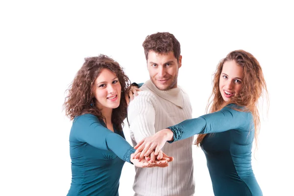 Drie gelukkige vrienden met handen op stapel — Stockfoto