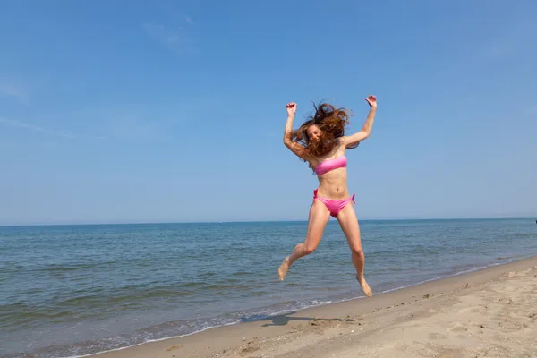 Mulher feliz pulando na praia em Seaside — Fotografia de Stock