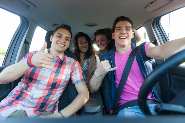 Cuatro amigos en el coche que salen de vacaciones — Foto de Stock