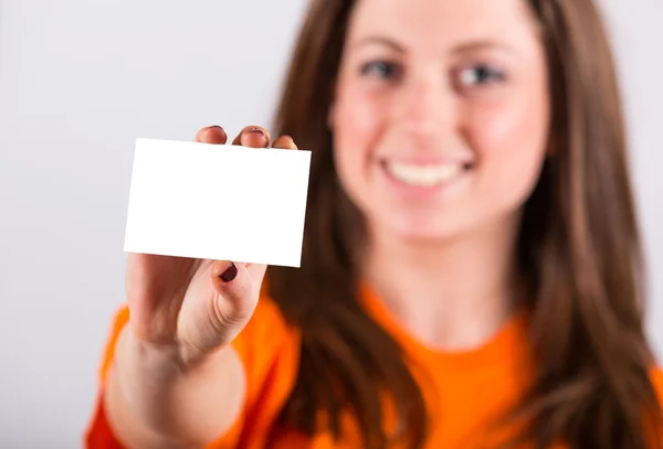 Joven mujer sosteniendo tarjeta en blanco — Foto de Stock