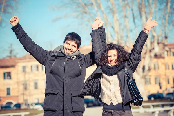 Pareja joven feliz con los brazos extendidos — Foto de Stock