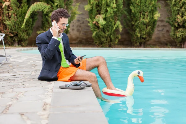 Rolig ung affärsman med swimmingtrunks vid poolen — Stockfoto