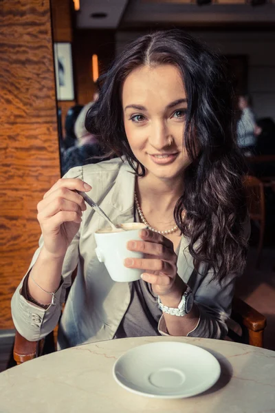Fiatal nő, egy csésze forró ital gazdaság — Stock Fotó