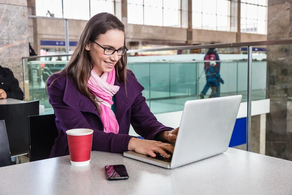 Ung kvinna inne flygplats eller tågstation — Stockfoto