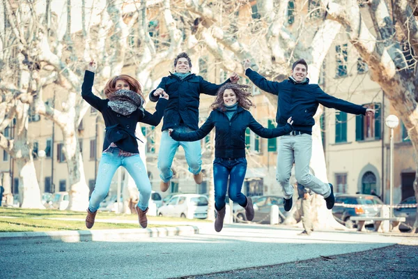 Grupo feliz de amigos saltando ao ar livre — Fotografia de Stock