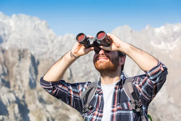 Junger Mann mit Fernglas am Berg — Stockfoto