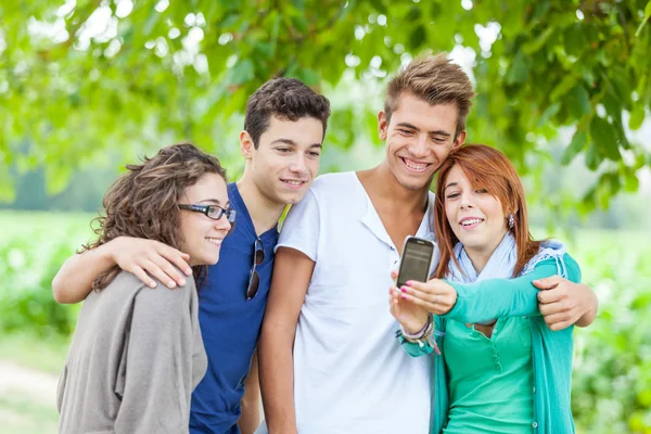 Grupp tonåriga vänner ta självporträtt med mobiltelefon — Stockfoto