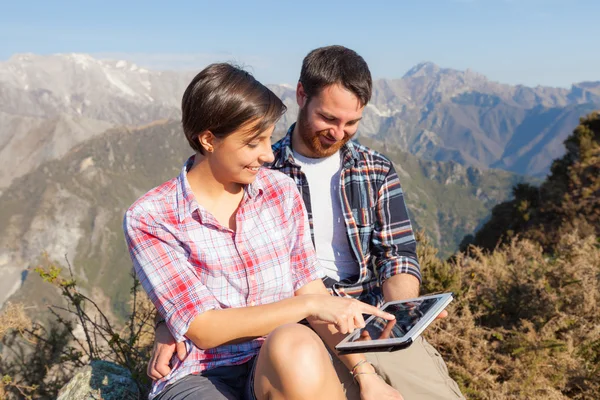 Pareja con tableta digital en la cima de la montaña — Foto de Stock