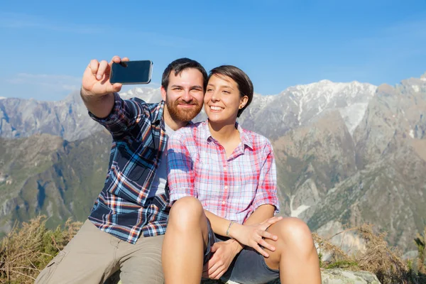 Casal tomando auto retrato no topo da montanha — Fotografia de Stock