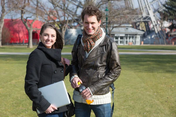 Pareja joven con computadora en el parque en Wien — Foto de Stock