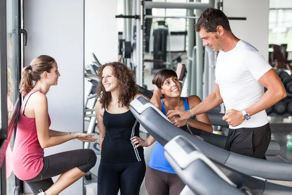 Hombre atractivo en el gimnasio con tres mujeres — Foto de Stock