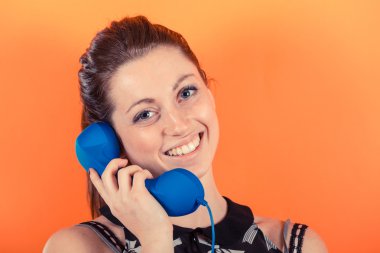 telefon alıcısı ile gülümseyen genç kadın