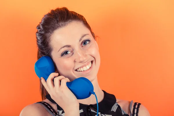 Uśmiechnięta młoda kobieta z odbiornikiem telefonu — Zdjęcie stockowe