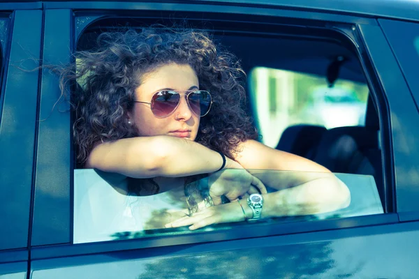 Застенчивая девушка, выглядывающая из окна автомобиля — стоковое фото